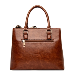Brown textured leather handbag with gold hardware, back zipper, and leopard silk scarf