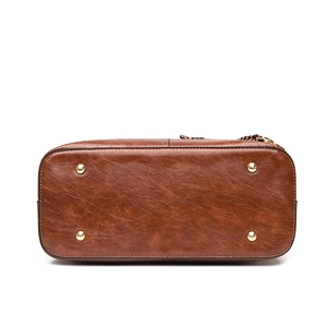 Bottom view of caramel brown crocodile pattern handbag with four gold metal protective feet