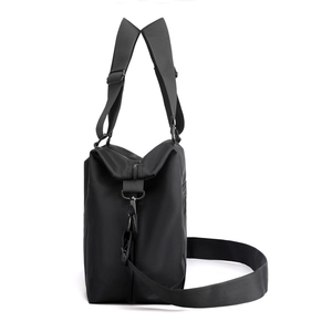 Borsa a spalla in nylon nero con doppi manici e tracolla regolabile su fondo bianco