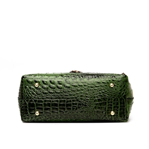 Green croc-embossed leather handbag with protective gold metal feet on the bottom