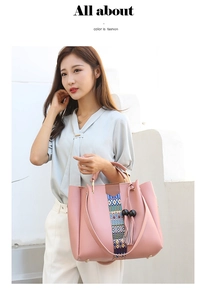 Détail du sac à main rose en similicuir avec motifs tissés colorés et pompons noirs
