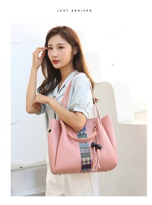 Sac fourre-tout rose avec ruban tissé coloré et pompon sur un mannequin femme