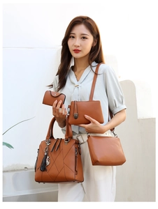 Detail view of 4-piece leather handbag set with tote, crossbody bag, clutch and cat charm
