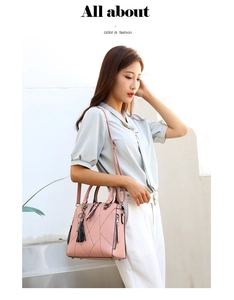 Pink quilted shoulder bag with decorative black fringe and metal charm accessory