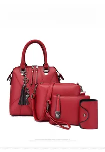 Detail of red faux leather 4-piece handbag set including tote with cat tassel charm