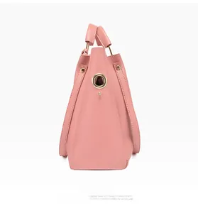 Vue latérale du sac seau rose en similicuir avec anneaux métalliques dorés et supports