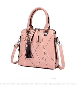 Detail of pink diamond-stitched handbag with black tassel and cat metal charm