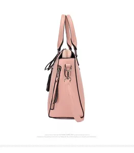 Detail view of pink leather handbag showing side zipper and tassel decoration features