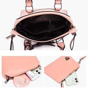 Detail view of pink handbag interior featuring multi-layer compartments and zipper pockets