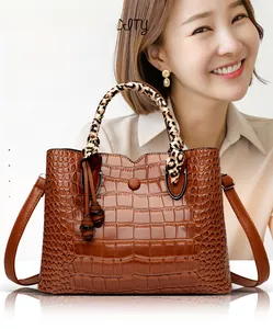 Detail of crocodile pattern bag with leopard scarf handle and fringe tassel detail