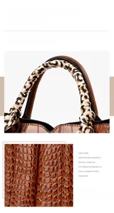 Close-up of brown crocodile texture leather and handle wrapped with animal print scarf