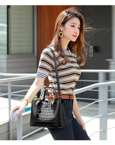 Close-up of black crocodile embossed handbag with decorative leopard print silk scarf