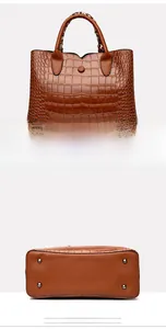 Detail view of yellow brown crocodile embossed handbag featuring protective bottom metal studs