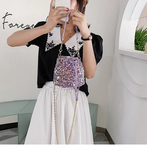 Close-up of shiny purple sequin bucket bag with golden chain and drawstring closure