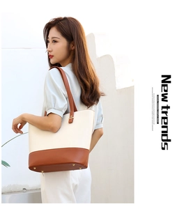 Detail of minimalist tote bag showing metal feet and contrast stitching in nature light