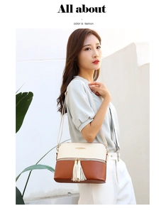 Close-up of two-tone PU leather shoulder bag with stylish white tassel and zipper detail