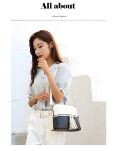 Fashionable black and white patchwork tote bag with tassel detail on a female model