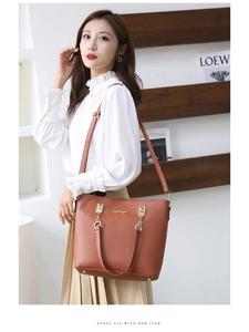 Sac fourre-tout en cuir marron avec bandoulière réglable et pieds de protection en métal