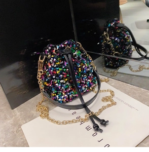 Detail of colorful sequins and gold chain strap on festive drawstring bucket bag