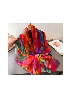Detail of artistic floral printed long silk scarf with vibrant abstract pattern and silky texture