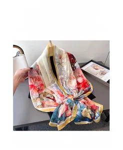 Detailed close-up of silk scarf with red peony floral print and yellow borders