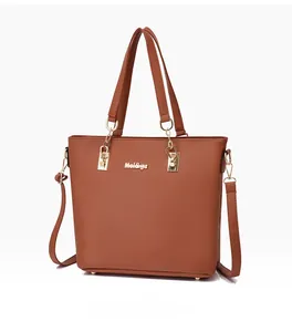 Détail d'un sac cabas marron caramel avec logo Mei&ge doré et pieds de sac en métal