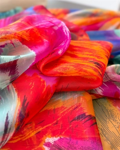 Macro detail of high-quality printed silk scarf featuring vibrant abstract art patterns