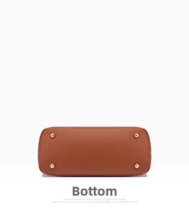 Vue détaillée du fond du sac en cuir marron avec quatre pieds de protection dorés