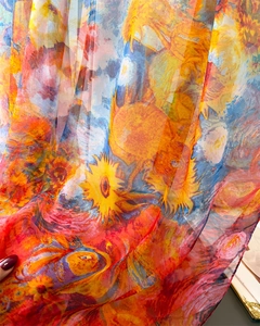 Close-up of translucent sunflower print scarf showing soft texture and vibrant colors