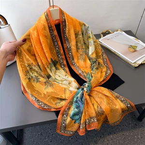 Orange floral scarf with white peony patterns and retro border on hangers