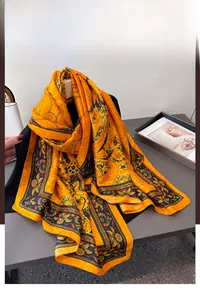 Detailansicht eines gelben Seidenschals mit schwarzen Vintage-Blumenmustern und Ranken