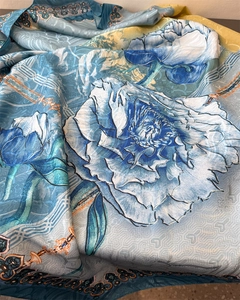 Detail of silk scarf showing giant blue peony print and traditional geometric pattern