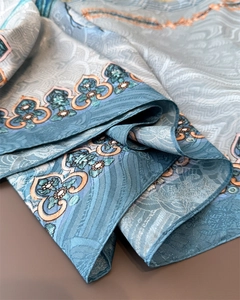 Detailed view of elegant blue floral silk scarf with vintage paisley pattern textures