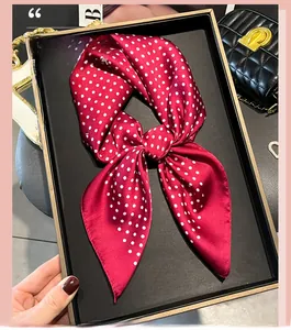 Detail of silk-like satin polka dot scarf in wine red with bow-tie style arrangement