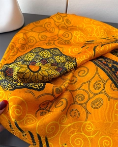 Detail eines orangefarbenen Seidenschals mit Spiralen und bunten Mandala-Mustern