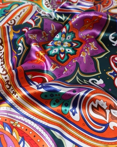 Detailed view of paisley printed satin scarf showing silky texture and vibrant patterns