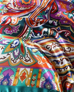 Macro shot of paisley pattern on emerald satin scarf with silky texture and folds