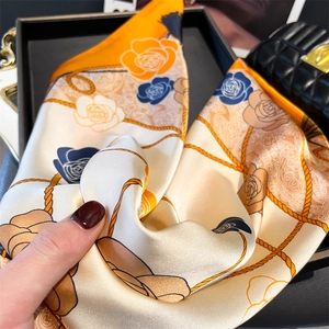Detail of silk-like satin square scarf showing floral pattern and smooth texture