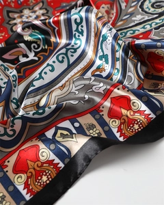 Close-up of vibrant paisley print on silky satin scarf with elegant material folds