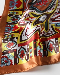 Macro view of satin scarf showing intricate paisley patterns and luxury fabric texture