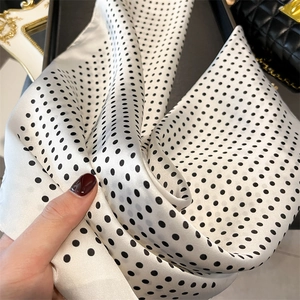 Macro shot of silk texture on cream square scarf with black polka dots for women