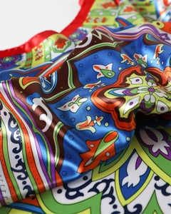 Macro shot of colorful paisley satin fabric with elegant drape and silky texture