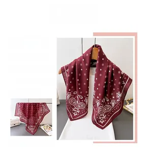 Macro detail of wine red paisley pattern satin scarf with elegant white borders
