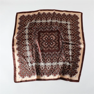 Détail du foulard carré en satin à motif cachemire avec des ornements marron et soie lisse