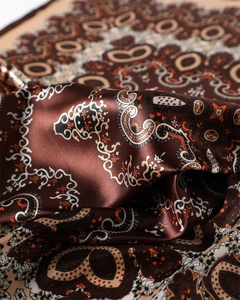 Gros plan d'un foulard en satin à motif paisley avec des plis élégants et brillants