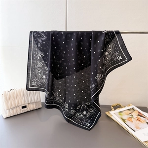 Detail of black paisley pattern scarf with star accents on breathable fabric