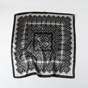 Détail d'un foulard carré en satin avec motif baroque complexe et texture soyeuse
