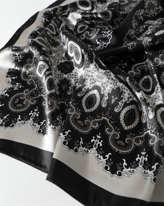 Gros plan détaillé d'un foulard en satin imprimé paisley montrant la texture lisse