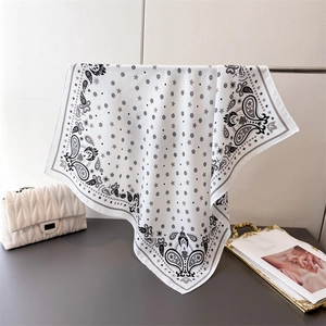 Detail of white paisley square scarf hanging with stars and geometric patterns