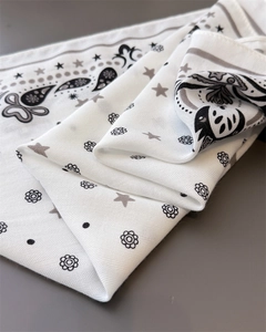 Close-up of white cotton-linen scarf with paisley patterns and soft fabric texture